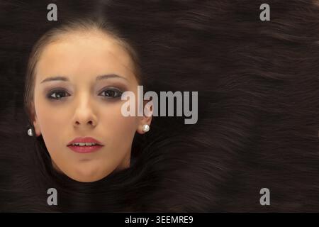 Close-up schöne schwarzhaarige Dame mit weißen Blumen im Haar Stockfoto