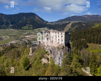 Blick aus der Vogelperspektive auf die historischen Steinruinen der Burg Likava, die auf einer felsigen Klippe liegt, umgeben von üppigen grünen Wäldern und Bergen Likavka, Zilina Regio Stockfoto