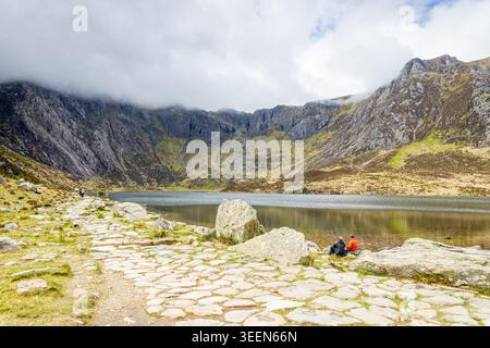 Ein atemberaubendes Landschaftsfoto des Gletschersees Llyn Idwal im Herzen von Eryri (Snowdonia). Das Bild zeigt einen steinernen Wanderweg Leadi Stockfoto