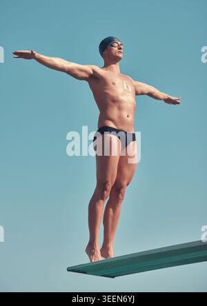 Sport, bereit und Mann mit Tauchbrett für Wellness, Training und Training auf blauem Hintergrund. Stretching, Fitness und Sportler oder Schwimmer für Stockfoto