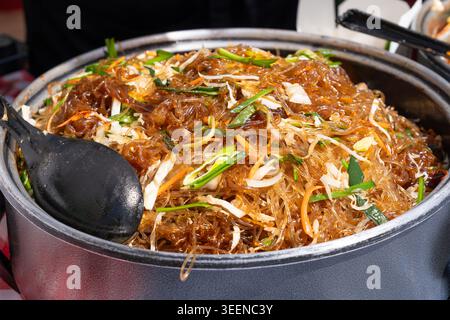 Glasnudeln Salat Street Food, chinesische Reisnudeln im Wok, asiatisches Pasta-Essen in einem großen Topf, koreanische Spaghetti, vietnamesisches Udon mit Gemüse und Sp Stockfoto