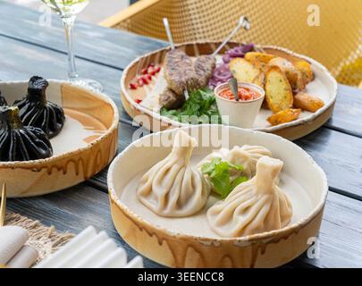 Georgische hinkali, Hackfleisch/Faschiertes Chinkali, scharfe Teigtaschen, auch Dimsum, momo, Jiaozi, Manti, Pierogi, Wonton oder Khinkali auf Restauranttteller Stockfoto