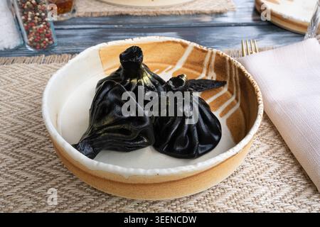 Schwarzer Chinkali, georgianische Meeresfrüchte-Chinkali, scharfe Teigtaschen mit Hackfleisch, auch Dimsum, momo, Jiaozi, Manti, Pierogi, Wonton oder hinkali auf Re Stockfoto