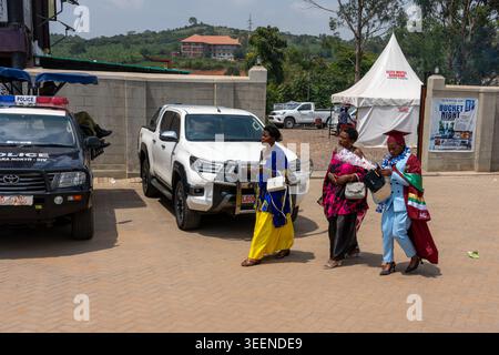 Studentinnen in Uganda, die traditionelle Kleidung tragen, nach einer Abschlussfeier, die auf der Straße lief. Stockfoto