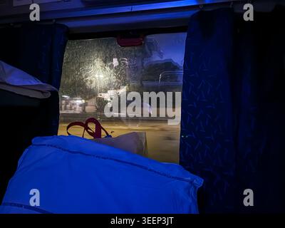 Perspektive der Bahnfahrt durch Fenster mit Bewegungsunschärfe und Geschwindigkeit bei Nacht Stockfoto