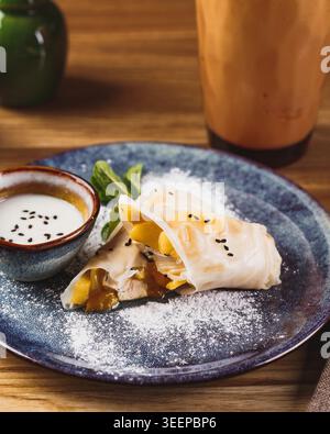Reis Frühlingsrollen NEM mit Früchten und süßer Soße auf Teller auf Holztisch. Asiatische vietnamesische Küche, Snack. Stockfoto