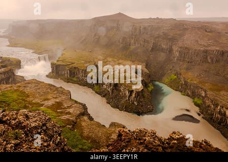 Island hat einige der erstaunlichsten Wasserfälle, von denen Sie träumen können. Dramatische Landschaften umgeben oft die Wasserfälle, wie diese Basaltfelsen. Stockfoto