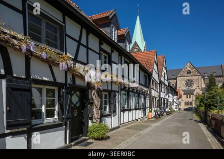 Deutschland, Herten, Ruhrgebiet, Westfalen, Nordrhein-Westfalen, NRW, Herten-Westerholt, Altdorf Westerholt, Alte Freiheit Westerholt, Häuserreihe, Fachwerkhäuser mit Blumenschmuck, hinter der katholischen Pfarrkirche St. Martinus, neoromanisch, Spätromantik, Radfenster am Querschiff Stockfoto