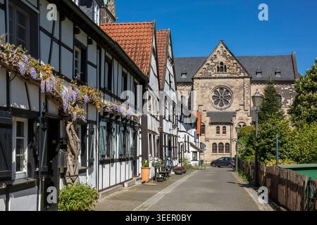 Deutschland, Herten, Ruhrgebiet, Westfalen, Nordrhein-Westfalen, NRW, Herten-Westerholt, Altdorf Westerholt, Alte Freiheit Westerholt, Häuserreihe, Fachwerkhäuser mit Blumenschmuck, hinter der katholischen Pfarrkirche St. Martinus, neoromanisch, Spätromantik, Radfenster am Querschiff Stockfoto