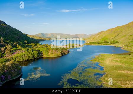 Der Pollacappul Lough in der Nähe von Kylemore Abbey leuchtet im Abendlicht unter den Bergen von Connemara, County Galway. Malerische Reiselandschaft über Seen, V Stockfoto