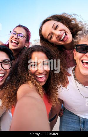 Gruppe glücklicher Freunde, die ein Selfie im Freien machen, lächeln und ein Friedenszeichen mit Gesten geben Stockfoto