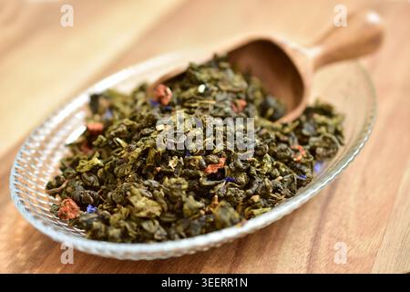Grüner Tee. Trockene grüne Teeblätter in einer Glasplatte. Stockfoto