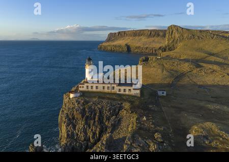 Luftaufnahme des Neist Point Lighthouse auf einer zerklüfteten Klippe mit Blick auf das blaue Meer während der goldenen Stunde in Isle of Skye, Schottland, Großbritannien. Stockfoto
