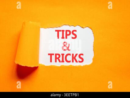 Symbol für Tipps und Tricks. Konzeptwörter Tipps und Tricks auf wunderschönem Whitepaper. Wunderschöner orangefarbener Hintergrund. Geschäftliche Tipps und Tricks Motivation Stockfoto