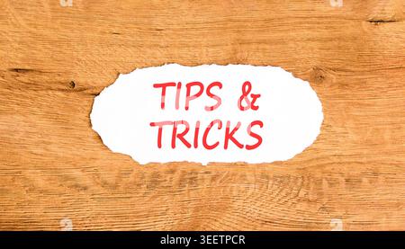 Symbol für Tipps und Tricks. Konzeptwörter Tipps und Tricks auf wunderschönem Whitepaper. Schöner Holzhintergrund. Geschäftliche Tipps und Tricks Motivation Stockfoto