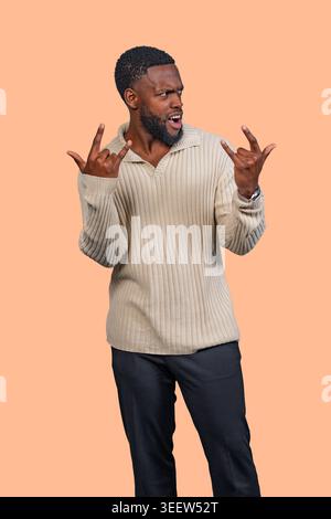 Mann zeigt Begeisterung und Energie mit einem Rock-and-Roll-Schild Stockfoto
