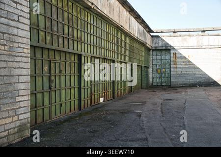 Verwitterte grüne Metall-Hangar-Türen an verlassenen Industriestandorten Stockfoto