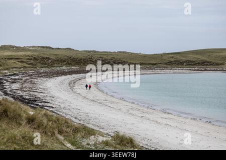 Ein Paar, das einen Spaziergang am Sandstrand im Naturschutzgebiet Balranald RSPB in North Uist, Äußere Hebriden, Schottland, macht Stockfoto