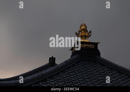 Minimalistisches japanisches Tempeldach mit Golden Dragon Ornament bei Sonnenuntergang Stockfoto