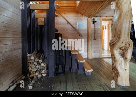 Holzeinrichtung mit Brennholz und Treppe Stockfoto