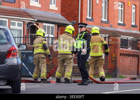 Ein Polizist, der den Verkehr von einem Brand im ehemaligen Festival Foods Lagerhaus in Osmondthorpe, Leeds, West Yorkshire, Großbritannien ablenkt Stockfoto