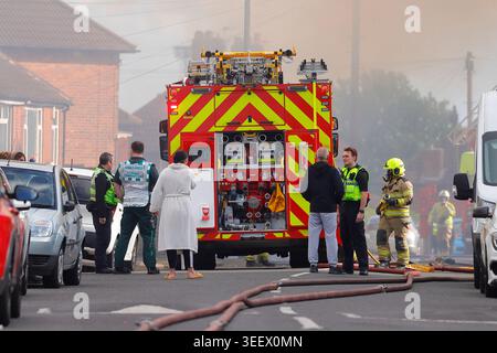 Feuerwehrmannschaft und Mitglieder der Öffentlichkeit am Ort eines Brandes im ehemaligen Festival Foods Warehouse in Osmandthorpe, Leeds, West Yorkshire, Großbritannien Stockfoto