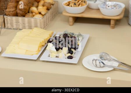 Buffet-Tisch mit einer Auswahl an Käsesorten, frischen Trauben und gebackenen Brötchen Stockfoto