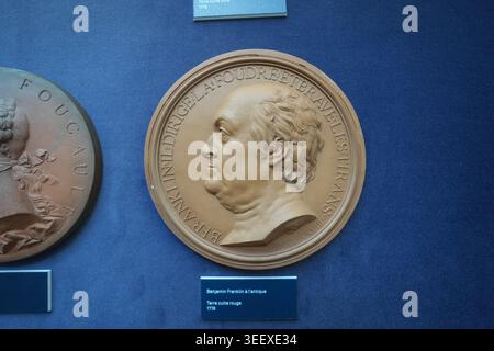 Ein Porträt von Benjamin Franklin aus dem Jahr 1778 von Jean-Baptiste Nini aus Terrakotta ist auf einer blauen Galeriewand im Château de Chaumont ausgestellt. Stockfoto
