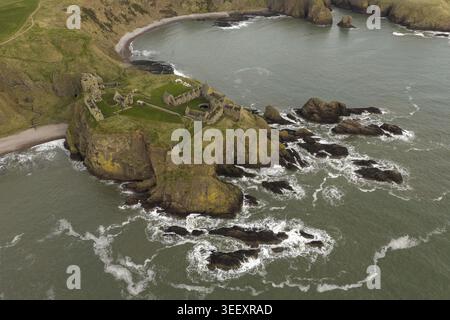 Blick aus der Vogelperspektive auf die mittelalterlichen Ruinen von Dunnottar Castle auf einer felsigen Landzunge, umgeben von der Nordsee und grünen Küstensteilküsten in Stonehaven, Stockfoto