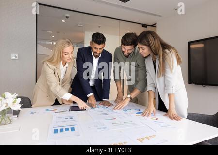Multinationale Gruppe prüft Karten während der Bürositzung Stockfoto