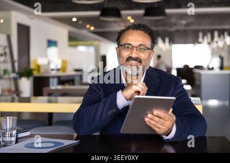 Porträt von lächelnden Geschäftsmann mit digital-Tablette in office Stockfoto