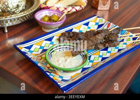 Marokkanisches Rindfleischspieß, traditionelles arabisches Essen, Hammel-Schaschlik, gegrilltes Kalbsfleisch, scharfer Lammgrill mit weißer Sauce Stockfoto