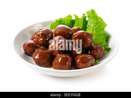 Fleischbällchen mit brauner Hochglanzsauce und grünem Salat in einer weißen Schüssel, isoliert auf weißem Hintergrund Stockfoto