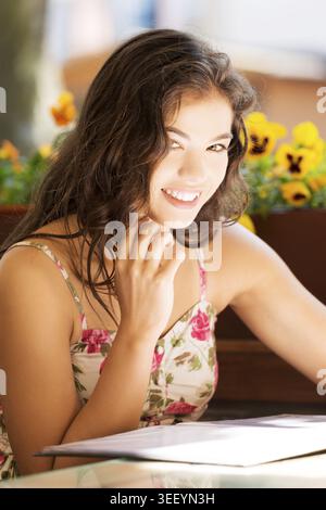 Eine junge Frau in einem Restaurant, die Speisekarte liest Stockfoto