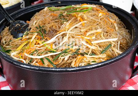 Glasnudeln Salat Street Food, chinesische Reisnudeln im Wok, asiatisches Pasta-Essen in einem großen Topf, koreanische Spaghetti, vietnamesisches Udon mit Gemüse und Sp Stockfoto