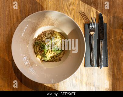 Pilz-Risotto auf elegantem Restaurant-Teller, Porcini Pilze Rissoto, köstliches italienisches Risoto-Mittagessen, cremige Reisgerichte, traditionelles Pilz-Risott Stockfoto