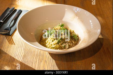 Pilz-Risotto auf elegantem Restaurant-Teller, Porcini Pilze Rissoto, köstliches italienisches Risoto-Mittagessen, cremige Reisgerichte, traditionelles Pilz-Risott Stockfoto