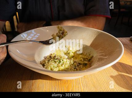 Pilz-Risotto auf elegantem Restaurant-Teller, Porcini Pilze Rissoto, köstliches italienisches Risoto-Mittagessen, cremige Reisgerichte, traditionelles Pilz-Risott Stockfoto