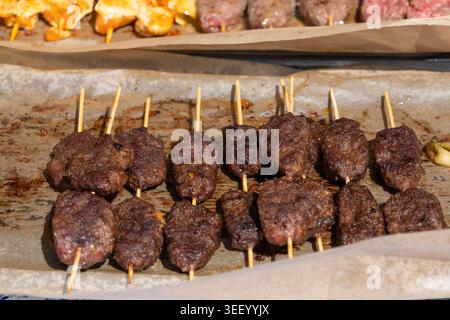 Kleine Spieße, Street Barbecue, Chicken Shish Kebab, Barbecue Shashlik, Spieße gegrillte Hühnerfleisch Stücke auf Papier Hintergrund Stockfoto