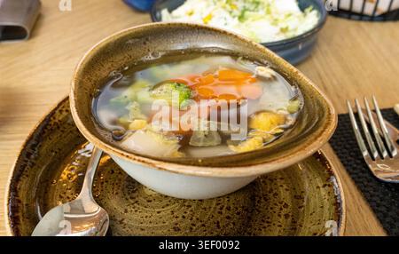 Gemüsesuppe, gesunde vegetarische Mahlzeit, Diätessen, transparente Gemüsebrühe mit Karotten, Kohl und Gewürzen in Restaurant Bowl Stockfoto