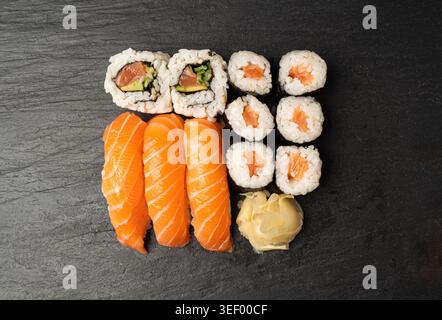Sushi-Set, Lachs Susi Rolls Lunch, Nori Maki, Nigiri Sushi Roll auf schwarzem Steinteller Hintergrund Stockfoto