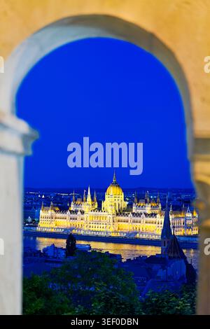 Budapest bei Sonnenuntergang, das Parlamentsgebäude auf der anderen Seite der Donau, wo die Lichter der Stadt zu leuchten beginnen. Stockfoto