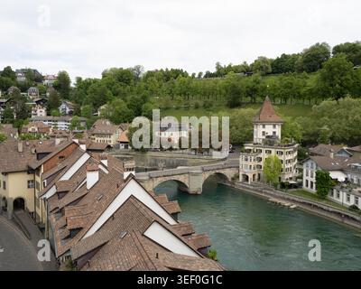 Historische Altstadt von Bern - Blick auf den Fluss mit roten Ziegeln, Steinbrücke und mittelalterlichem Turm über die Aare Stockfoto