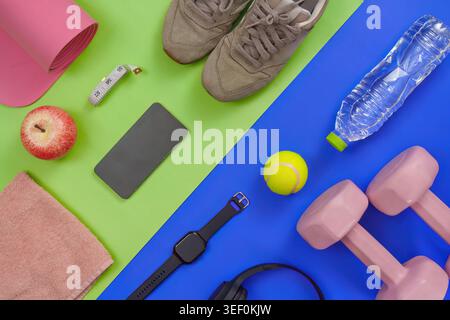 Fitness Workout Essentials flach mit Kurzhanteln, Yogamatte und intelligenten Geräten Stockfoto