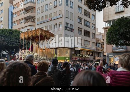 Almeria, Spanien - 30. März 2026: Zuschauer treffen sich, während ein Prozessionswagen der Karwoche mit einem heiligen Bild der Jungfrau Maria durch eine Menschenmenge zieht Stockfoto