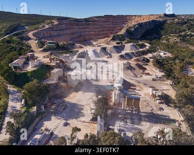 Industrielle Steinbrucharbeiten Mit Beton- Und Asphaltproduktion, Luftaufnahme Des Bergbaus Und Windturbinen In Manilva, Spanien Stockfoto