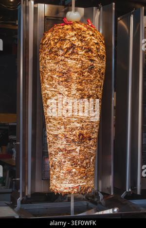Shawarma- oder Dönerfleisch-Kochen auf vertikalem Grill in der Fast-Food-Küche. Das Bild zeigt traditionelle Straßenkost-Zubereitung mit Deliciou Stockfoto