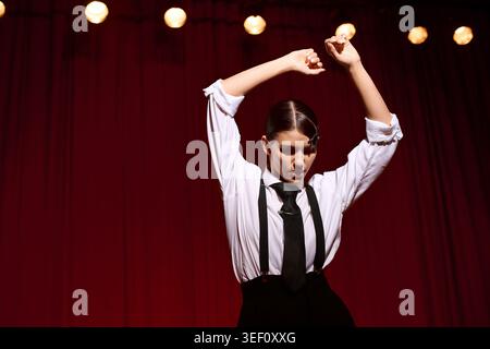 Eine junge Frau fesselt das Publikum mit ihrem ausdrucksstarken Tanz in einer intimen Umgebung. Stockfoto