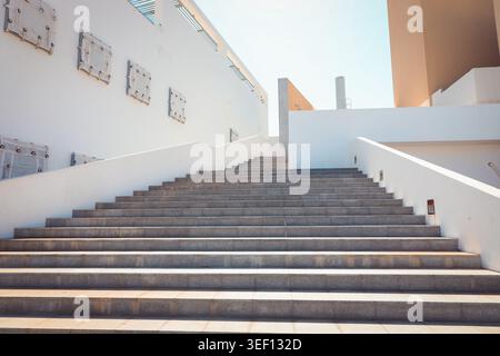 Cabo San Lucas, Mexiko, Oktober 4,2025: Minimalistischer architektonischer Blick auf eine breite Betontreppe, die in einem modernen, klaren blauen Himmel nach oben führt Stockfoto