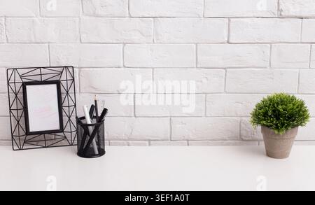 Moderne Büro Tabelle mit Rahmen für Foto- und grüne Pflanze Stockfoto